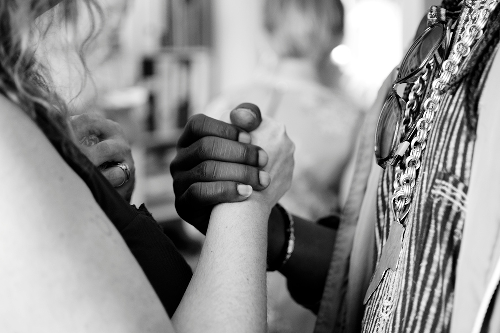 Two people clasping hands (Unsplash/Aaron Blanco)