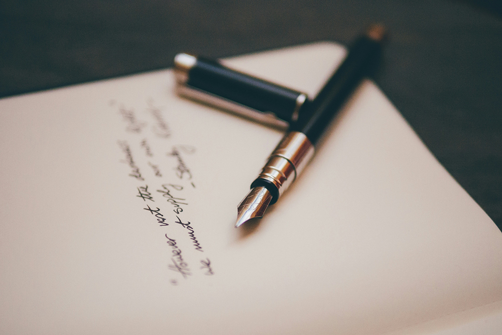 A fountain pen with written words on a page (Unsplash/Alvaro Serrano)