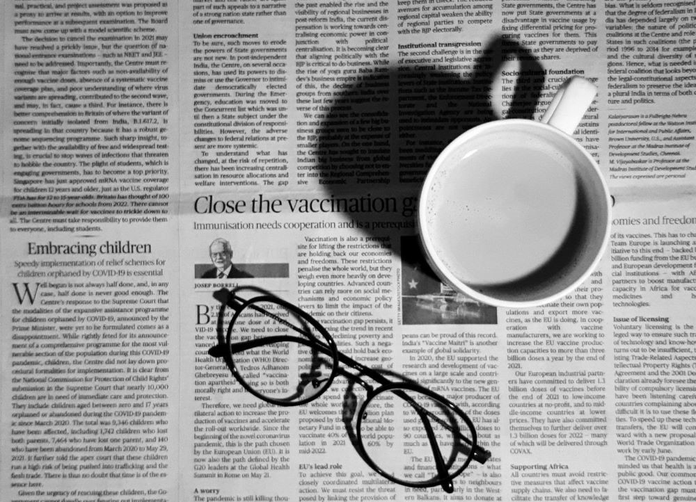 mug and eyeglasses on newspaper