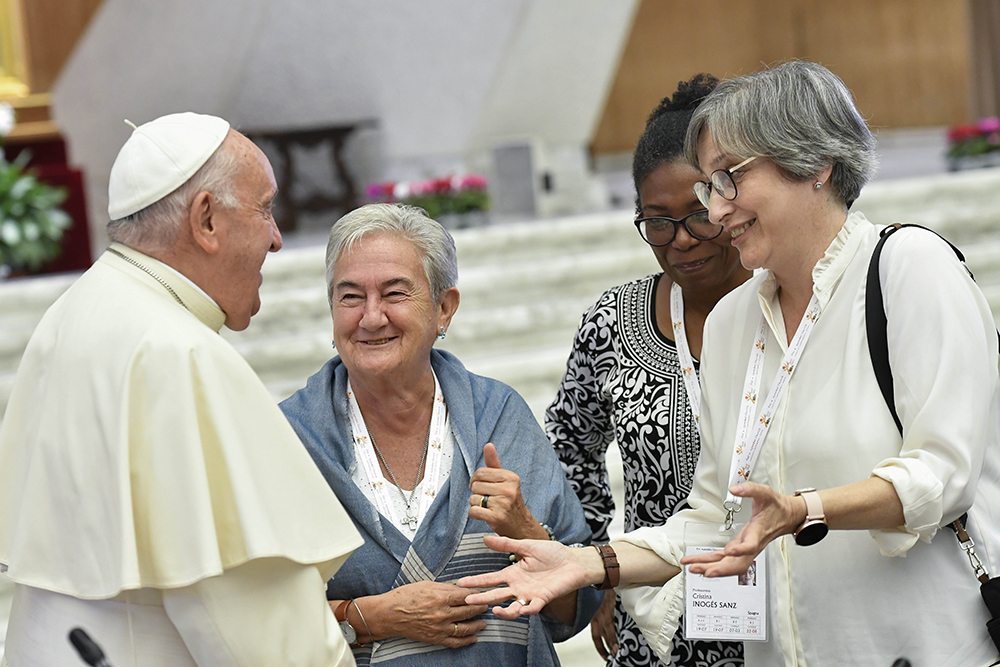 Pope Francis shares a laugh with some of the women members of the assembly of the Synod of Bishops, including Spanish theologian Cristina Inogés Sanz, left, at the assembly's session Oct. 6, 2023, in the Paul VI Audience Hall at the Vatican. (CNS/Vatican Media)