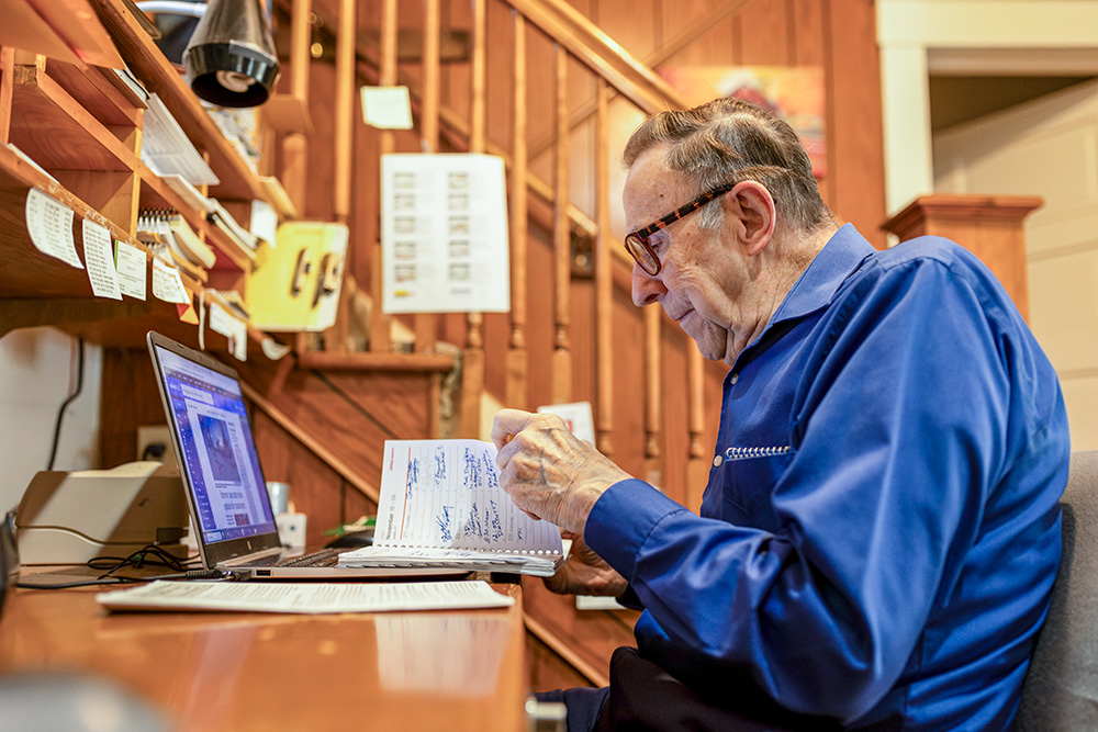 Mel Beckman reviews his appointment book at his work desk. Mel left the priesthood as a young man but continued living a service-oriented life. (Flatwater Free Press/Joseph Saaid)