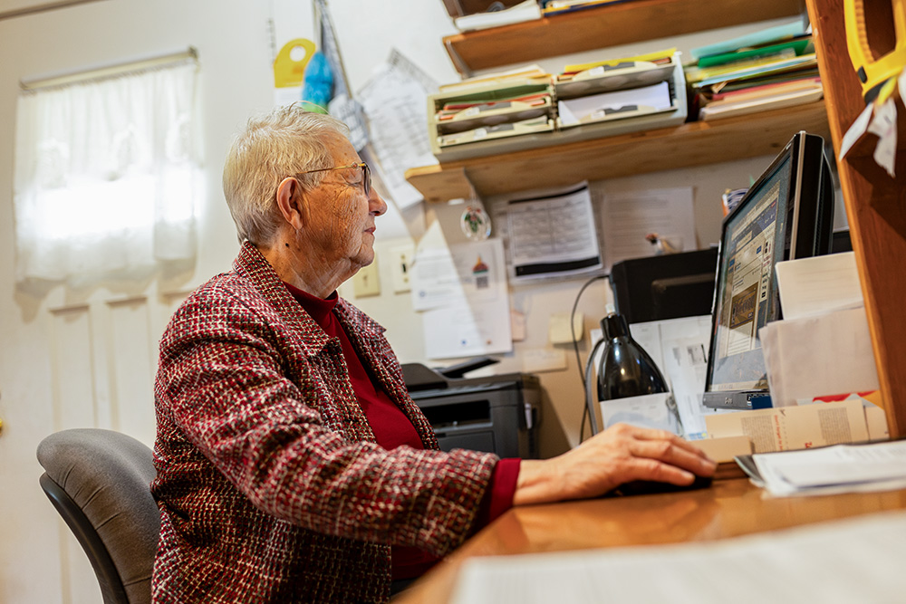 Mary Ann Beckman works on her computer in the Beckman home. Mary Ann spent most of her adult life working for Catholic Charities. (Flatwater Free Press/Joseph Saaid)