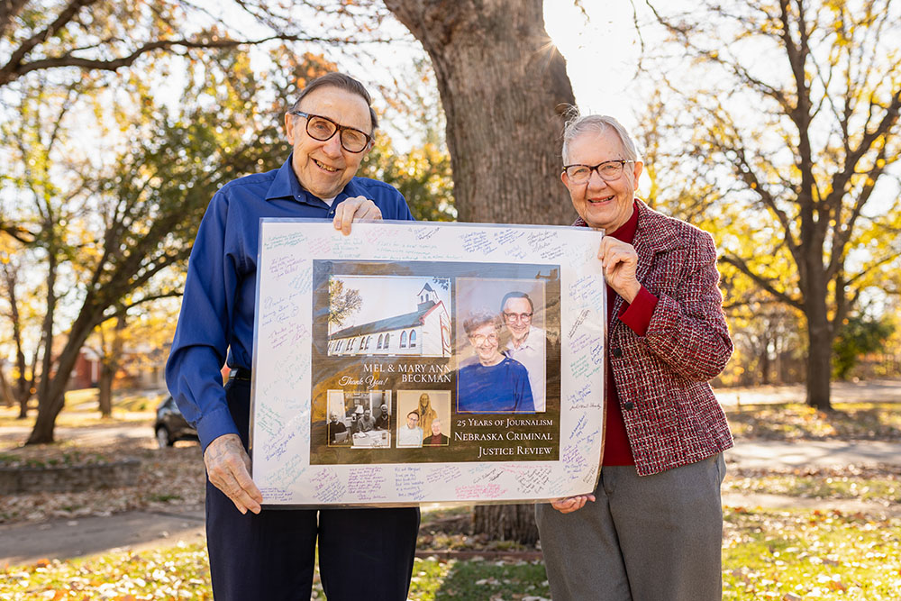 Mel and Mary Ann Beckman proudly hold their signed poster gifted to them earlier this month at a reception hosted at the old Holy Family Catholic Church. The Beckmans attended Holy Family for many years until the Omaha Archdiocese closed the church during the pandemic. (Flatwater Free Press/Joseph Saaid)