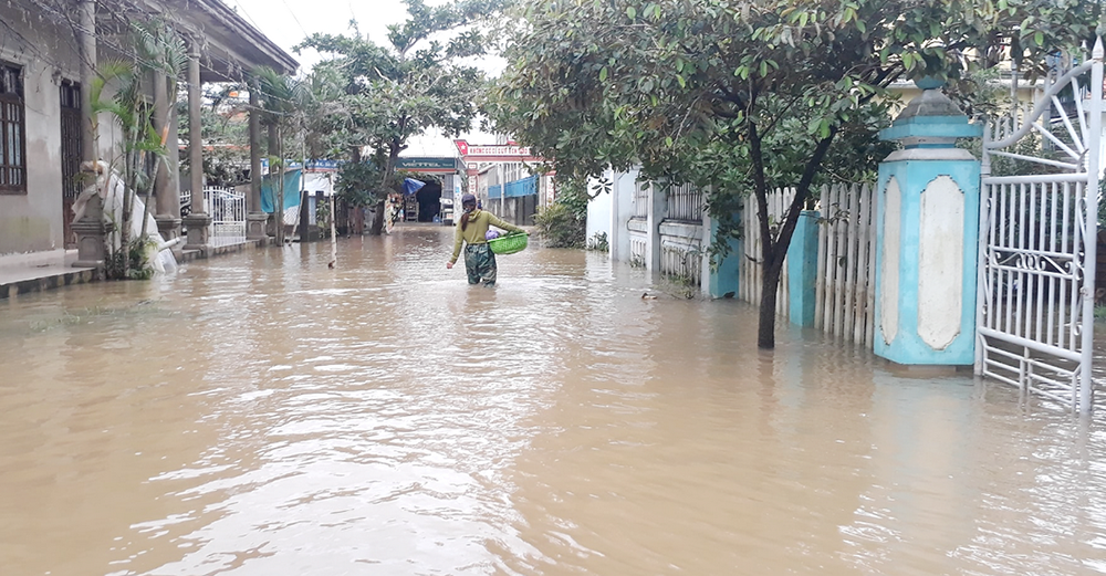 A woman wades through flood water in Quang Dien district in Thua Thien Hue province on Nov 27. (Joachim Pham)