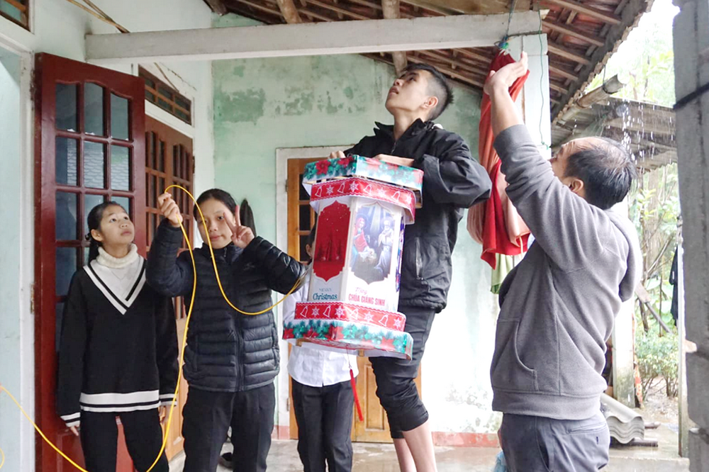 Volunteers hang a lantern in a house of a non-Catholic family in Quang Dien district in Thua Thien Hue province in Vietnam on Dec. 15. (Joachim Pham)