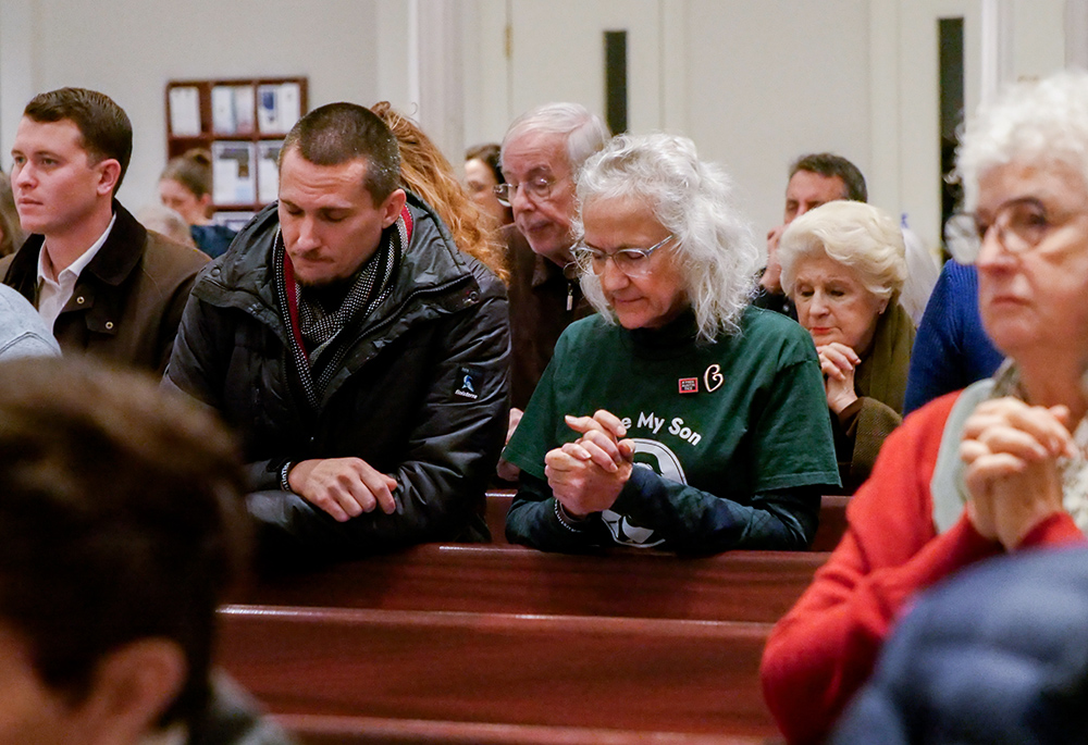 Debra Tice and her son Simon Robert pray during a Vigil Mass Dec. 15 at Holy Trinity Church in Washington. (NCR photo/Anthony Peltier)