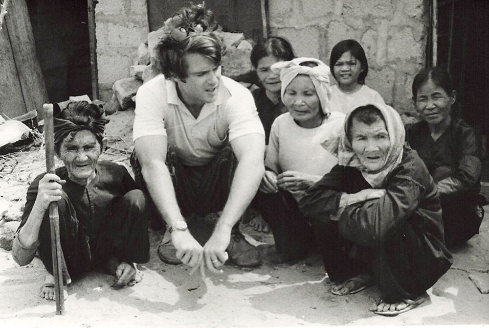 Thomas C. Fox speaks with Vietnamese refugees at the Dong Tac camp in 1967, which offered minimal shelter to several thousand war refugees, situated outside Tuy Hoa, Vietnam. (Courtesy of Thomas C. Fox)