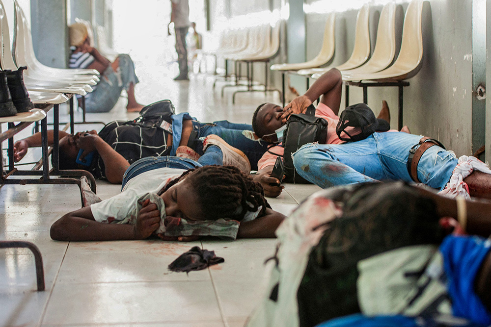 Injured people lie on the ground after armed men opened fire on a group of journalists who gathered for a government press conference set to announce the reopening of the General Hospital in Port-au-Prince, Haiti, Dec. 24, 2024. (Reuters/Fildor Pq Egeder/File Photo)