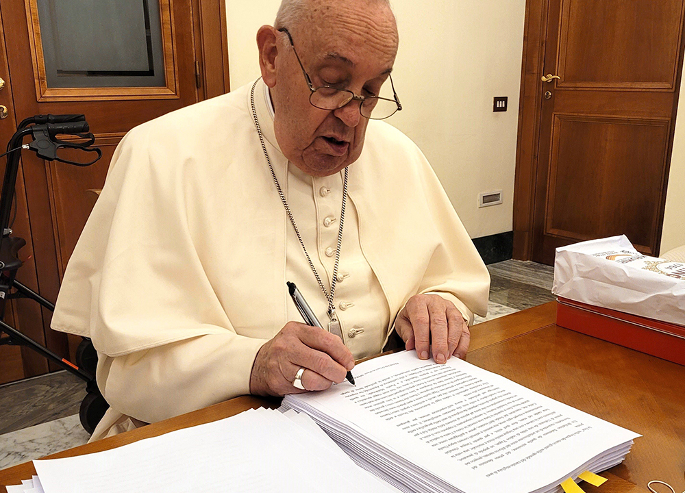 Pope Francis reviews and initials each page of the manuscript of Hope: The Autobiography Aug. 9, 2024, in his Vatican residence, the Domus Sanctae Marthae. The book was released in multiple languages Jan. 14. (CNS/Courtesy of Mondadori)