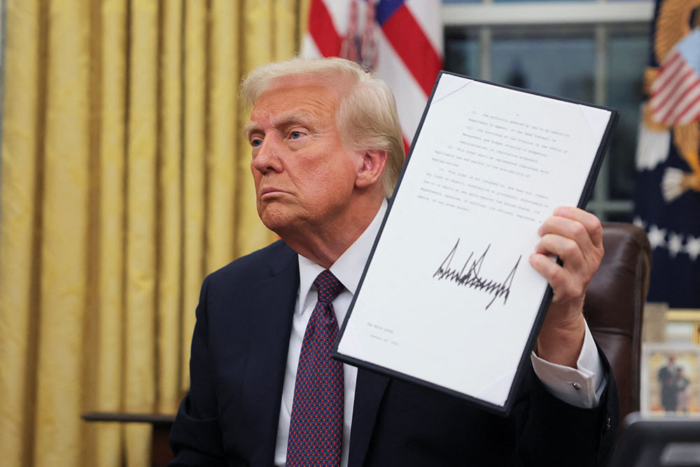 U.S. President Donald Trump signs documents in the Oval Office at the White House on Inauguration Day in Washington Jan. 20, 2025. He signed a series of executive orders including on immigration, birthright citizenship and climate. Trump also signed an executive order granting about 1,500 pardons for those charged in connection with the Jan. 6, 2021, riot at the U.S. Capitol. (OSV News/Reuters/Carlos Barria)