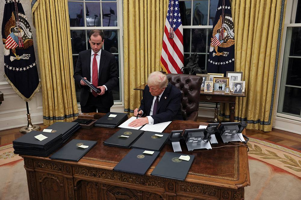 U.S. President Donald Trump signs documents in the Oval Office at the White House on Inauguration Day in Washington Jan. 20, 2025. (OSV News/Reuters/Carlos Barria)