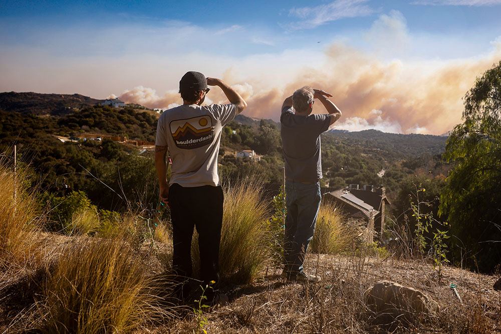 Topanga Canyon inhabitants look on as the Palisades Fire burns in the hills between Pacific Palisades and Malibu Jan. 8, 2025, in Topanga, California. (AP/Etienne Laurent)