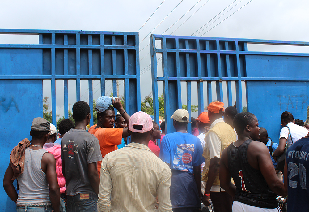 People are pictured on the Haitian side of the border between Haiti and the Dominican Republic, near Ouanaminthe, Haiti, in northeast Haiti. This entry point is for people to meet friends or family returning to Haiti from the Dominican Republic or for people to pass through the border legally. But many Haitians cross the border elsewhere in hopes of going to the Dominican Republic to find work without legal documentation. (GSR photo/Chris Herlinger)