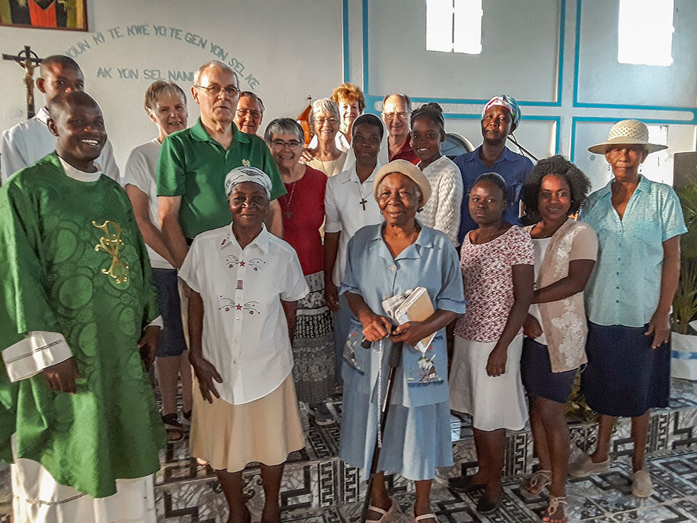 Haitian parishioners from Our Lady of the Assumption Church and Ken Firling (on the mule), a member of St. Margaret Mary Catholic Church in Winter Park, Fla., make a three-hour journey by foot and hoof to one of the Haitian parish's outlying chapels, Our Lady of Mercy. These chapels only see their pastor once a month for Mass. The rest of the time they have an administrator who conducts prayer services and oversees other parish activities. (Courtesy of St. Margaret Mary Church)