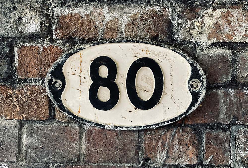 Number 80 on a brick wall (Unsplash/Jonny Gios)