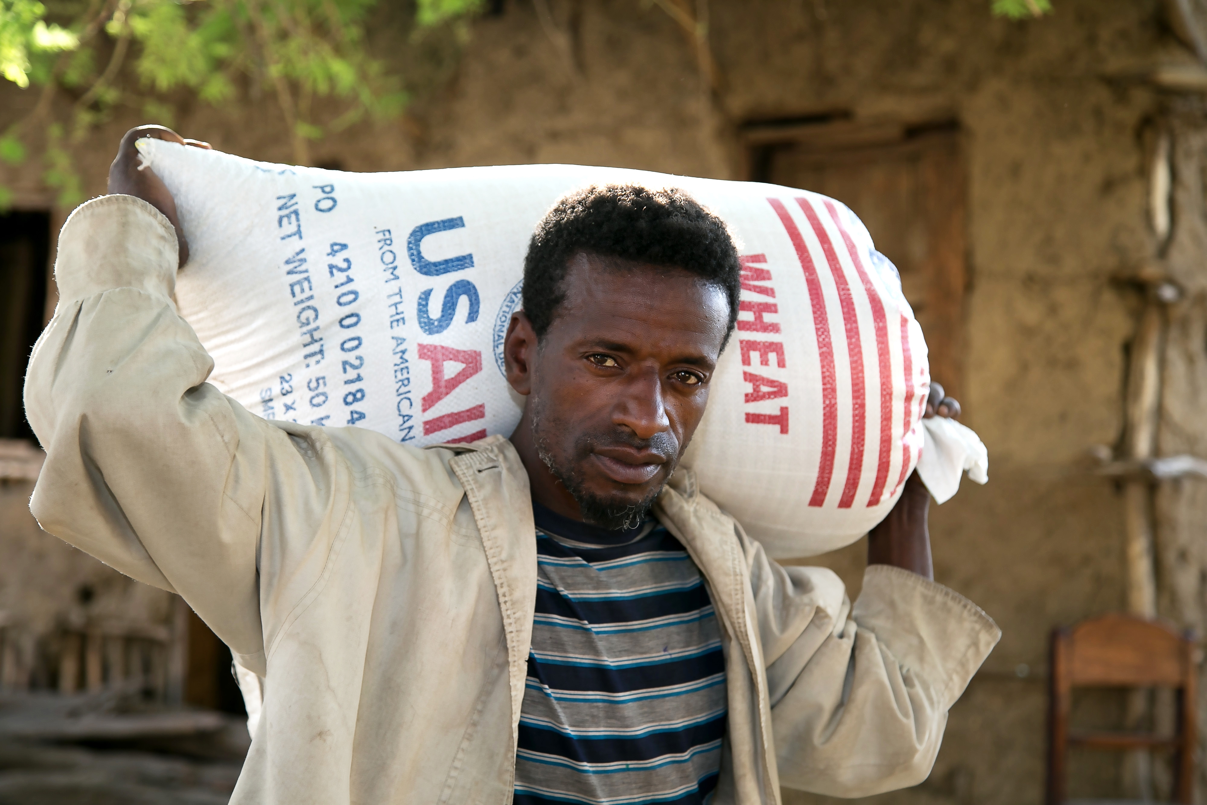 A man carries a bag of wheat supplied by Catholic Relief Services and USAID for emergency food assistance in a village near Shashemane, Ethiopia, in this 2016 photo. As acute hunger is expected to double in vulnerable populations because of the coronavirus pandemic, CRS launched an advocacy campaign May 14, 2020, to raise awareness about the world's hungriest people. (CNS Photo/Nancy McNally, Catholic Relief Services) 