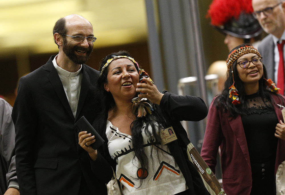 Fr. Dario Bossi, provincial superior of the Comboni Missionaries in Brazil, Patiachi Taylor and Leah Rose Casimero leave the final session of the Synod of Bishops for the Amazon at the Vatican Oct. 26, 2019. (CNS/Paul Haring)