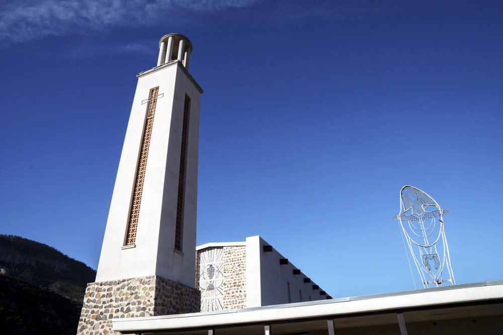 Bell tower looms against blue sky. 