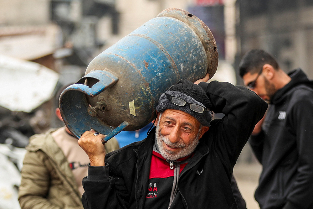 A Palestinian man carries a propane tank Feb. 3, 2025, in Gaza City, Gaza Strip, amid a ceasefire between Hamas and Israel. (OSV News/Reuters/Dawoud Abu Alkas)