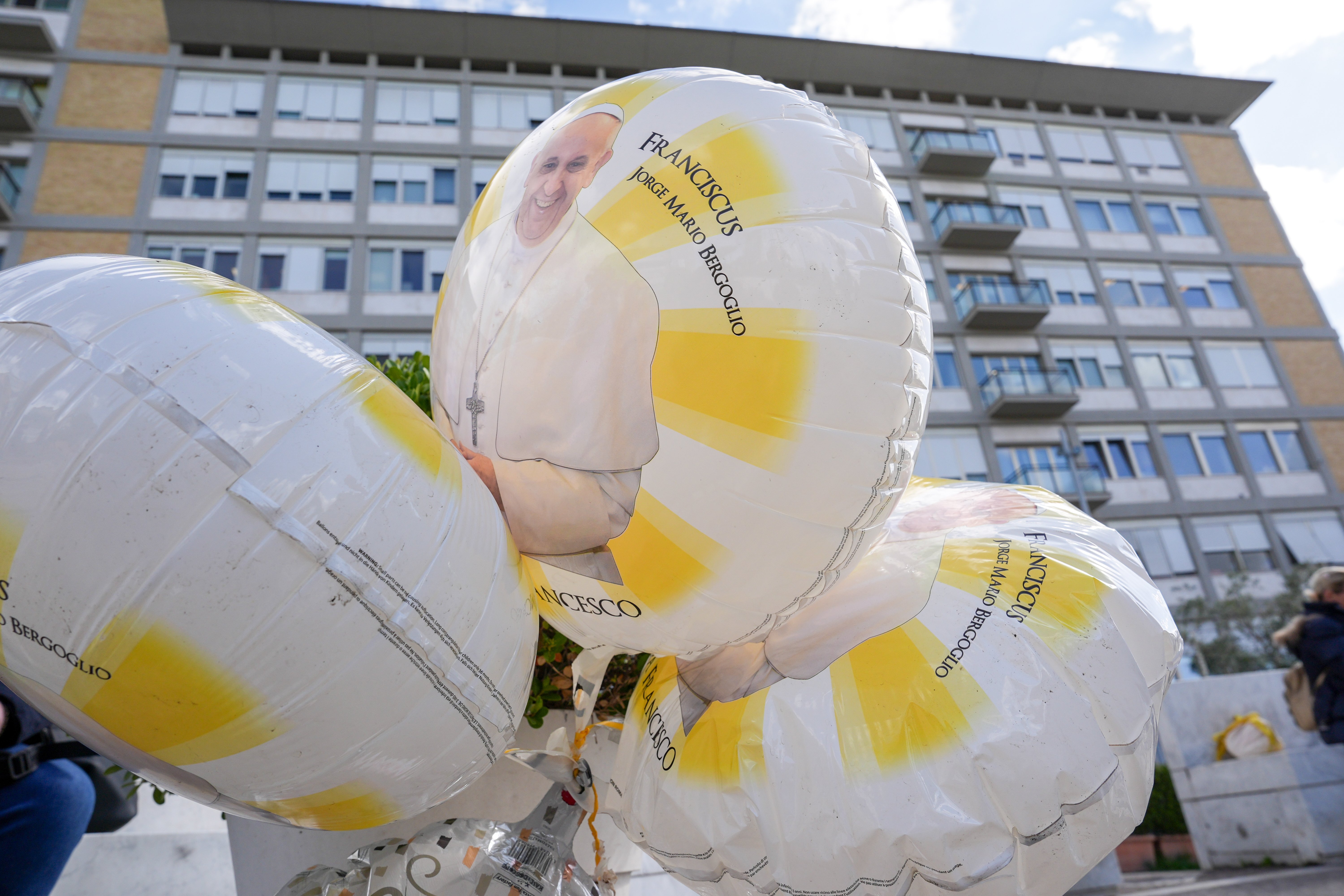 Balloons featuring an image of Pope Francis are seen outside Rome’s Gemelli hospital Feb. 27, 2025, while the pope is being treated there for double pneumonia. (CNS photo/Lola Gomez)