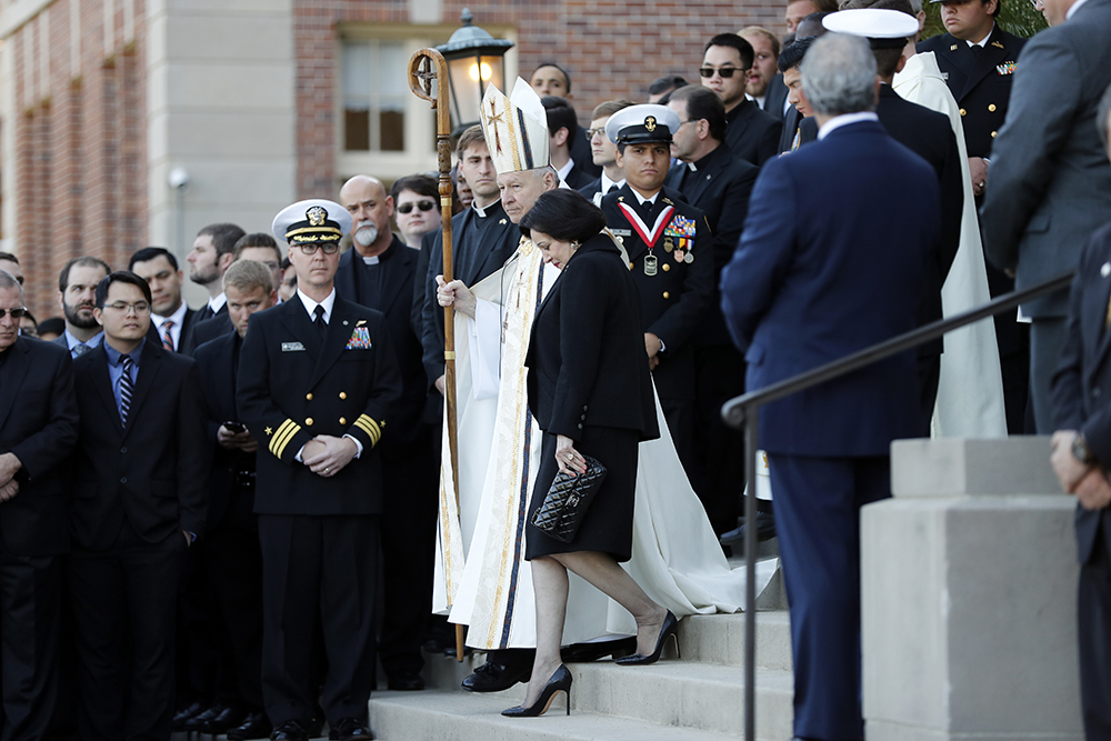 Gayle Benson, widow of NFL New Orleans Saints and NBA New Orleans Pelicans owner Tom Benson, walks down the steps to receive his casket with New Orleans Archbishop Gregory Aymond for visitation at Notre Dame Seminary in New Orleans on March 21, 2018. (AP file photo/Gerald Herbert)