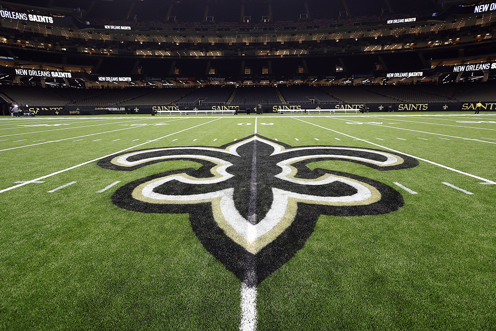 The fleur-de-lis logo of the New Orleans Saints is displayed on the 50-yard line of the field after an NFL preseason football game between the New Orleans Saints and the Tennessee Titans, Aug. 25, 2024, in New Orleans. (AP file photo/Tyler Kaufman)