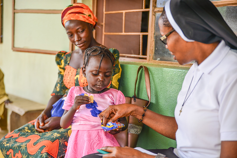 Sr. Juliana Ekwoanya chats with a child who visited the Hope for the Village Child Foundation clinic with her mother, in Kaduna, north central Nigeria. (Patrick Egwu)