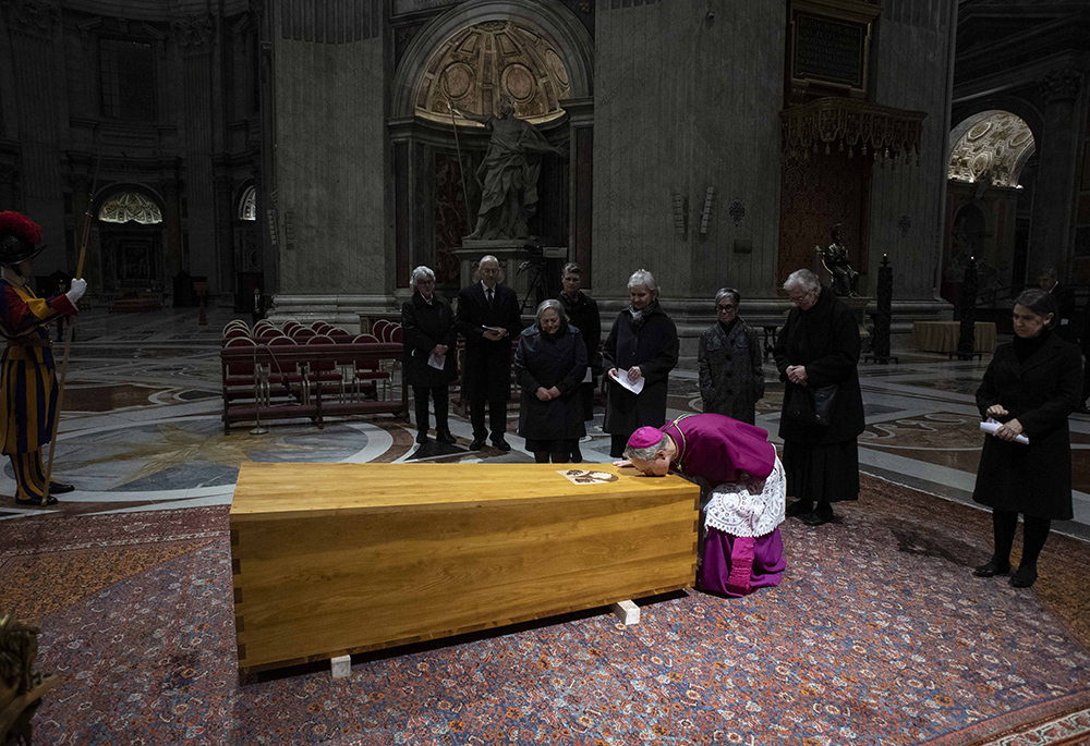 Archbishop Georg Gänswein, private secretary to Pope Benedict XVI, kisses the coffin of the late pope after his body was placed into it in St. Peter's Basilica at the Vatican on Jan. 4, 2023. (CNS/Vatican Media)