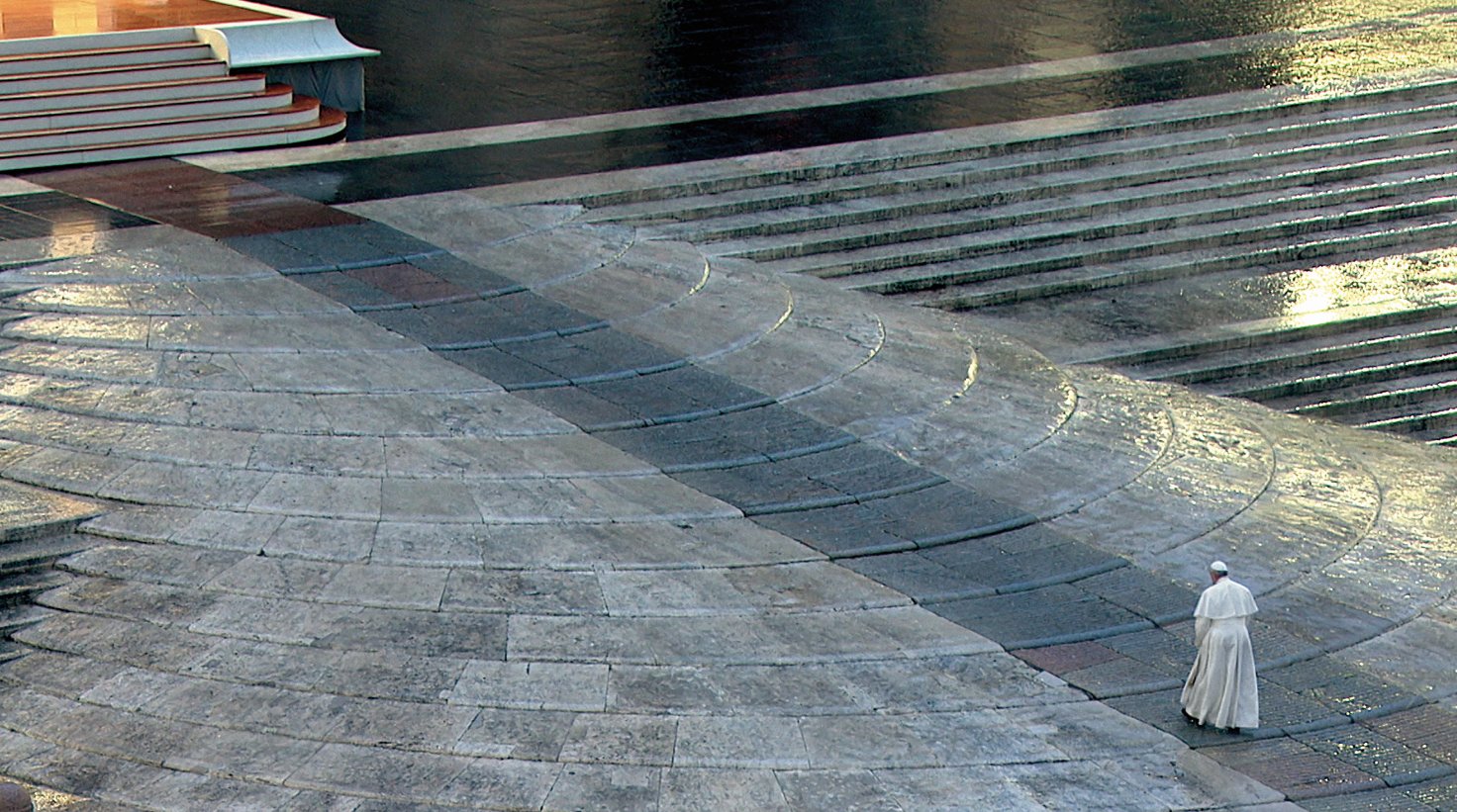 Pope Francis walks across an empty St. Peter's Square at the Vatican March 27, 2020.