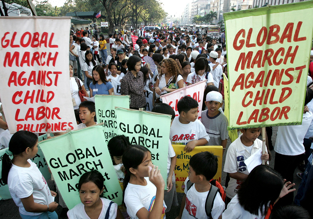 Filipino youths are pictured in a file photo as they carry placards during the celebration of the Global March Against Child Labor in Manila. (OSV News/Reuters/Romeo Ranoco)