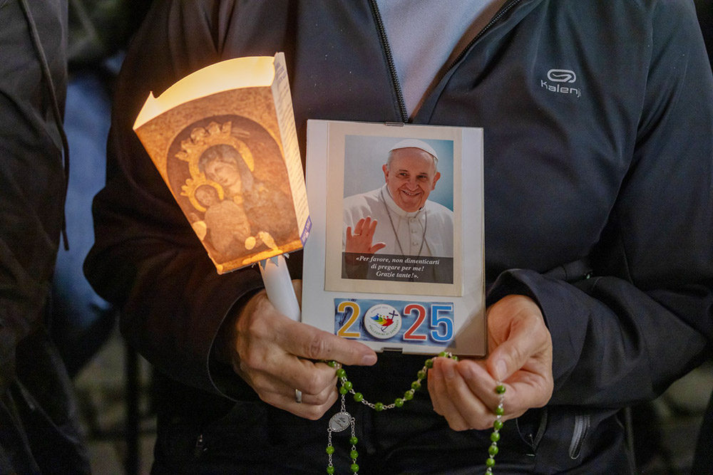 A woman joins Cardinal Michael Czerny, prefect of the Dicastery for Promoting Integral Human Development, in reciting the rosary for Pope Francis in St. Peter's Square at the Vatican March 8, 2025. Cardinals living in Rome, leaders of the Roman Curia and the faithful joined the nighttime prayer. (CNS/Pablo Esparza)