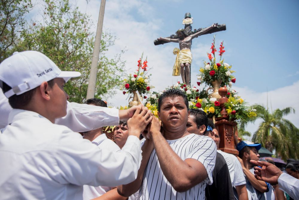 People hold crucifix during Good Friday procession. 