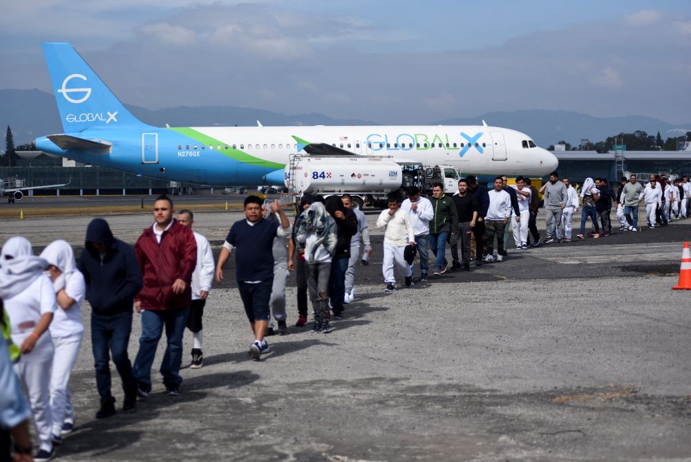 Migrants walk away from plane,