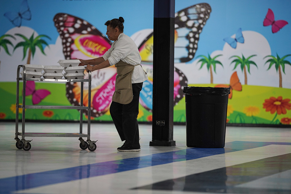 A volunteer delivers meals for migrants seeking asylum who are waiting at a Catholic Charities center for humanitarian assistance and relief in McAllen, Texas, Jan. 18, 2025. In the same state, Catholic Charities in Galveston-Houston and Fort Worth have made legal filings against the Trump administration's freeze on aid for refugee resettlement. (AP/Eric Gay)