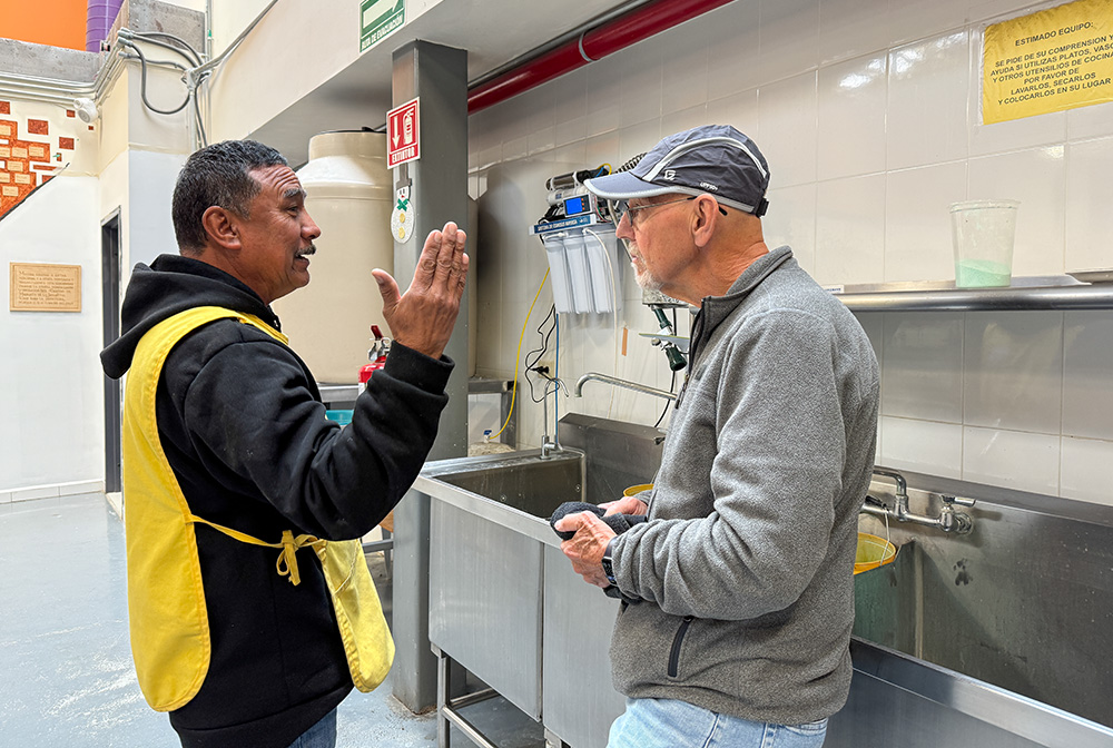 Volunteer Bob Kee, right, a retired dental technician from Tucson, chats on Feb. 19, 2025, with maintenance worker Victor Lara at the Kino Border Initiative in Nogales, Mexico. (Anita Snow)