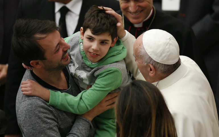 Pope Francis greets a boy while meeting the disabled during his general audience in Paul VI hall at the Vatican Nov. 30. (CNS photo/Paul Haring)