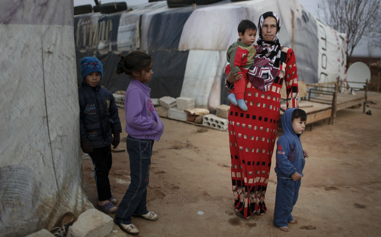 A mother stands with her children in 2014 in an informal tented settlement near Deir el Ahmar in the northern Bekaa Valley, Lebanon. (CNS photo/Sam Tarling, CRS) 