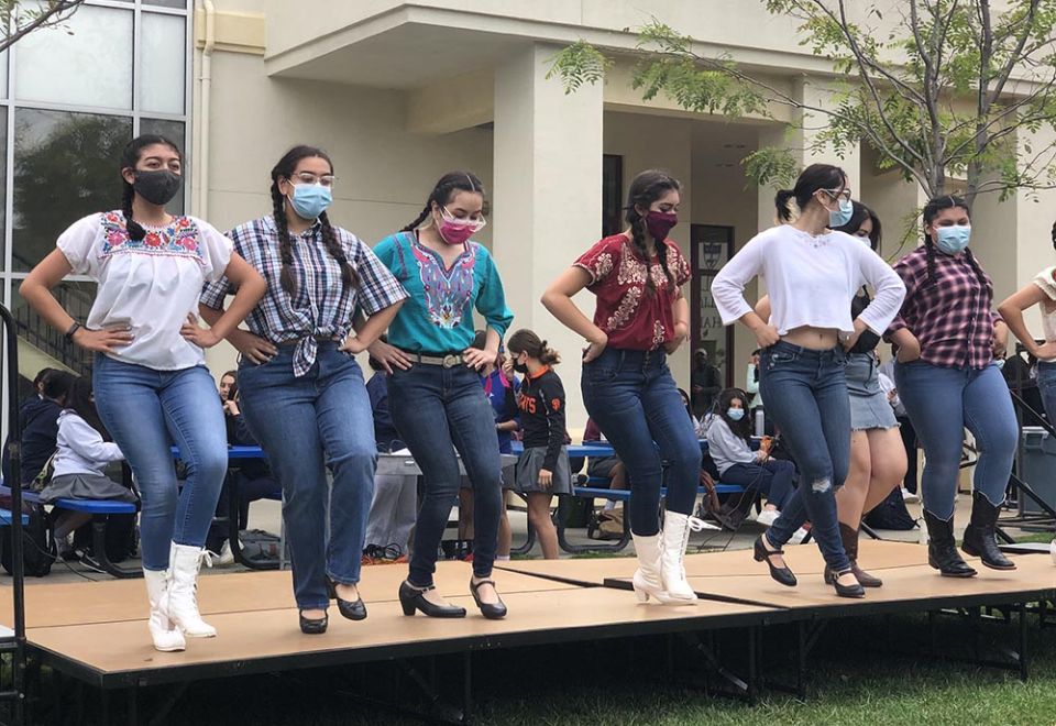 Lupita Castañeda-Liles, fourth from the left, takes part in a performance of a Mexican folkloric dance group she is part of at Notre Dame High School in San José, California. (Courtesy of Monica Gomez)