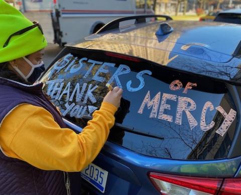 Jesuit Volunteer Salena Ibrahim inscribes thanks on a Sisters of Mercy automobile participating in defending Detroit election Nov. 3. (Courtesy of Sr. Erin McDonald, CSJ)