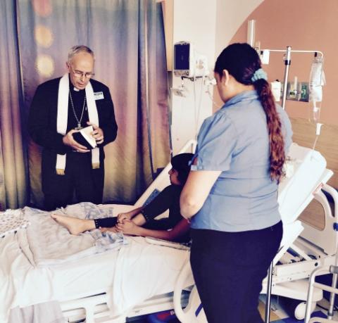 Bishop Mark Seitz of El Paso, Texas, prays with Maria De Loera and her 8-year-old daughter, Alia, Aug. 7. (CNS/Courtesy of Hope Border Institute/Dylan Corbett)