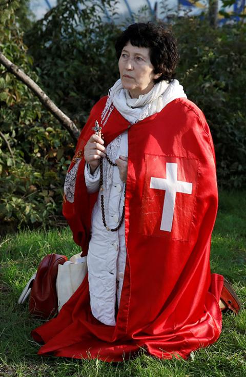 A demonstrator prays holding a rosary during an Oct. 24, 2020, rally in Warsaw, Poland, against measures imposed by the Polish government to stem the spread of the coronavirus. (CNS/Reuters/Kacper Pempel)