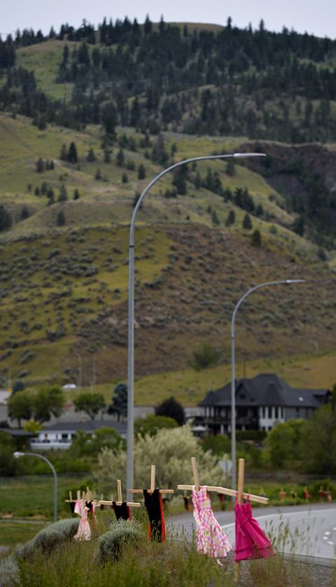 Children's dresses hang on crosses near the grounds of the former Kamloops Indian Residential School June 6. (CNS/Reuters/Jennifer Gauthier)