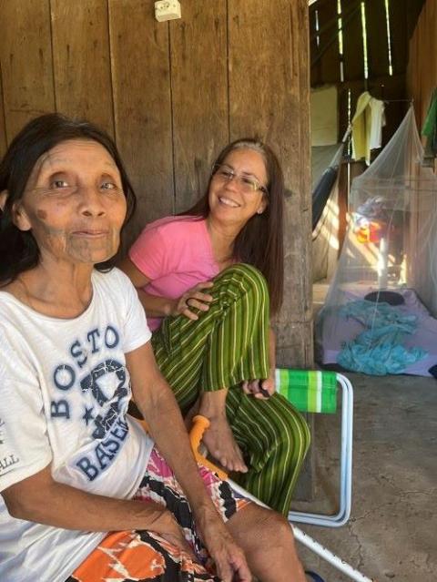 Irmã Laura Vicuña Pereira Manso (atrás) acompanha a matriarca Katiká e o povo Karipuna há mais de sete anos na defesa de seus direitos humanos e do cuidado com a floresta amazônica no território Karipuna, Brasil. Ela tem sido a presença da Igreja Católica neste território remoto onde não há padres. (Ellie Hidalgo)