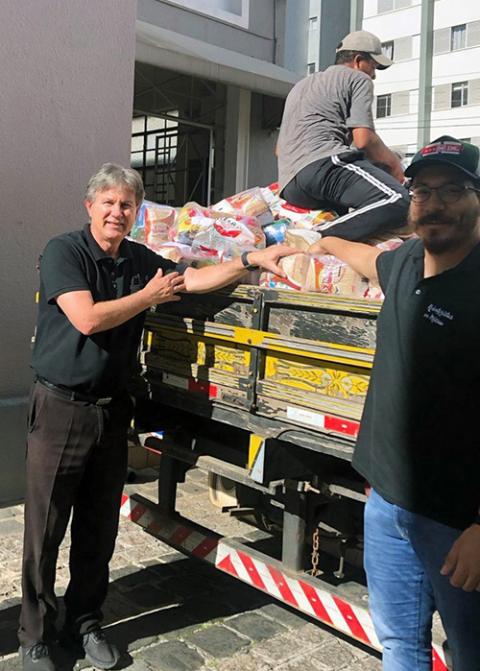 Fr. Joaquim Parron, left, and members of his team from the Congregation of the Redemptorist Fathers load baskets of practical goods for destitute families on the outskirts of Curitiba, Paraná, southern Brazil, Sept. 12, 2023. (RNS/Courtesy of Joaquim Parron)