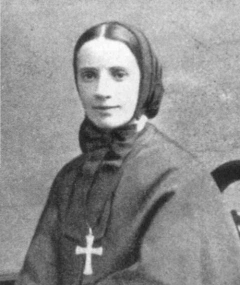 Black and white portrait of Mother Cabrini, relatively young; hair covered, large cross around neck. 