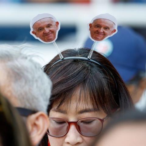 A woman wears a pope-themed headband as she awaits Mass with Pope Francis at the Gelora Bung Karno Stadium in Jakarta, Indonesia, Sept. 5.