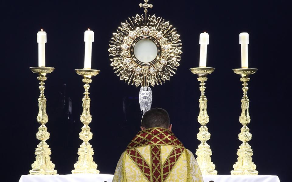 Bishop Andrew Cozzens of Crookston, Minnesota, chairman of the board of the National Eucharistic Congress Inc., kneels in prayer before the monstrance during Eucharistic adoration at the opening revival night of the 10th National Eucharistic Congress, July 17 at Lucas Oil Stadium in Indianapolis. (OSV News/Bob Roller)