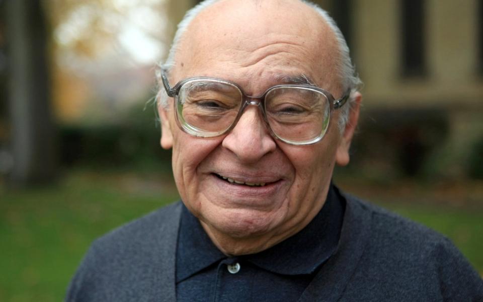 An elderly Gutiérrez faces camera with warm, beaming smile. 