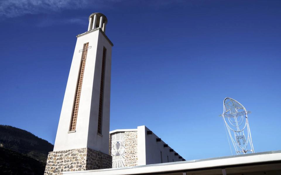 Bell tower looms against blue sky. 