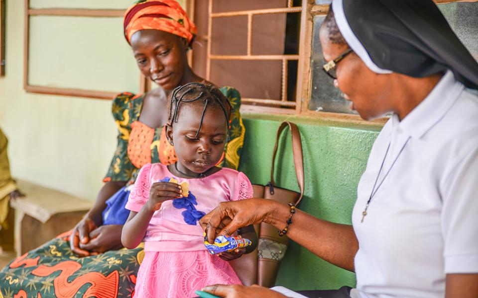 Sr. Juliana Ekwoanya chats with a child who visited the Hope for the Village Child Foundation clinic with her mother, in Kaduna, north central Nigeria. (Patrick Egwu)